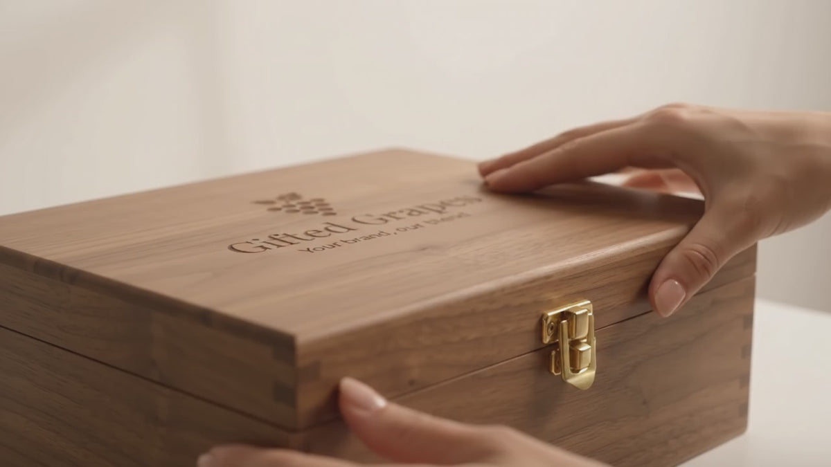 Video laden: Unboxing van een luxe houten wijnkist met drie verschillende flessen wijn en een wenskaart.
